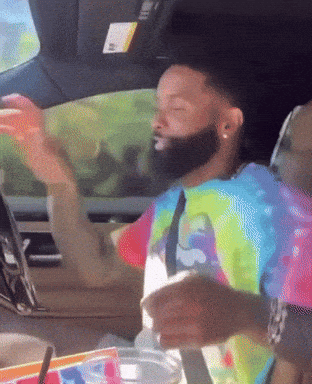 Tie Dye Shirt Man in Car With Arms Outstretched