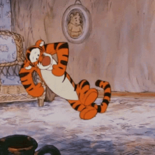 Tigger From Winnie The Pooh Is Laying Down In A Living Room GIF