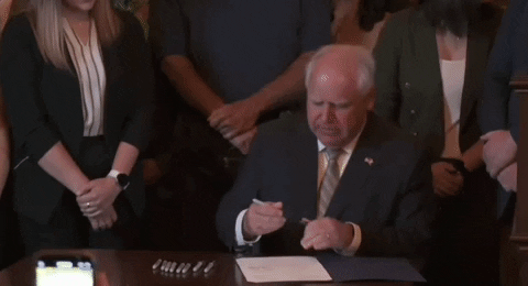 Tim Walz Showing The Signed Law GIF