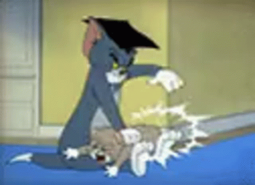 Tom And Jerry Are Fighting Each Other In A Room . GIF