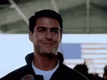 Tom Cruise Is Smiling And Looking At The Camera While Wearing A Jacket . GIF