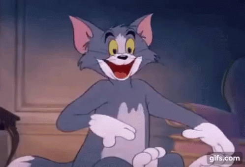 Tom From The Cartoon Tom And Jerry Is Sitting On The Floor With His Mouth Open . GIF