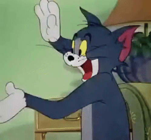Tom From The Cartoon Tom And Jerry Is Waving His Hand In A Room . GIF