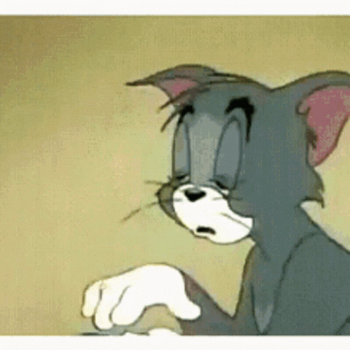 Tom From Tom And Jerry Is Sitting Down With His Eyes Closed . GIF
