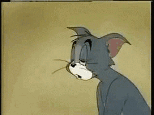 Tom From Tom And Jerry Is Sitting Down With His Eyes Closed And A Sad Look On His Face . GIF