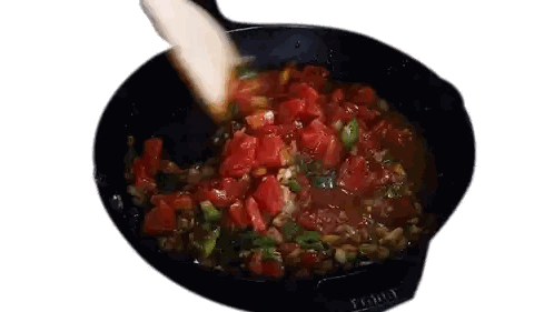 tomatoes are being stirred in a skillet with a wooden spatula