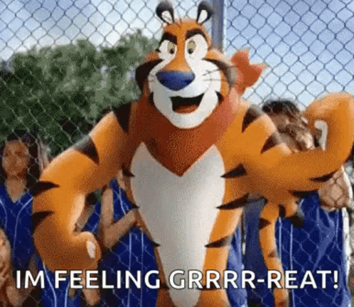 Tony The Tiger Standing In Front Of Chain Link Fence With People Behind GIF