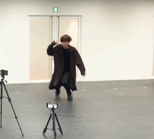 Trench Coat Man Dancing Next to Camera Tripod