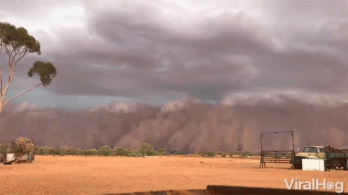 Truck Parked in Dirt Under Cloudy Sky