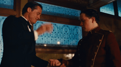 Tuxedo Man Shaking Hands with Red Uniform Man