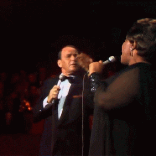 Tuxedo Man Sings to Woman in Black Dress