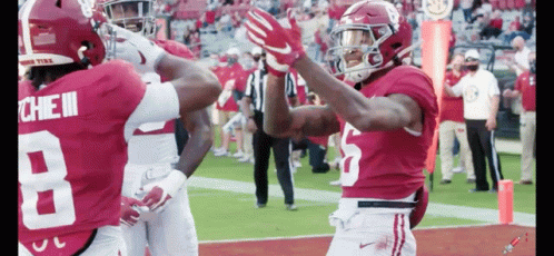 Two Alabama Football Players Are High Fiving Each Other GIF