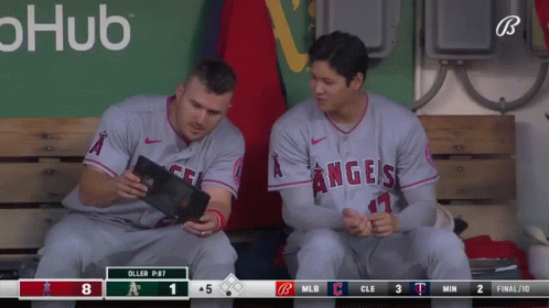 Two Angels Baseball Players Sit On A Bench Looking At A Tablet GIF
