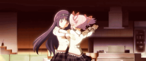 Two Anime Girls Are Hugging Each Other In A Living Room GIF