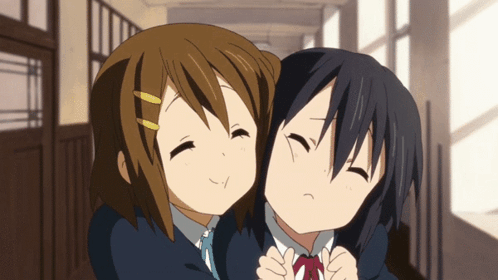 Two Anime Girls Hugging Each Other In A Hallway With Their Eyes Closed GIF