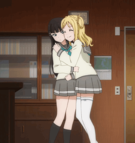 Two Anime Girls Hugging in Front of Calendar