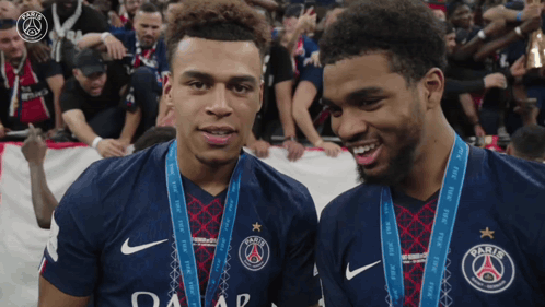 Two Athletes With Medals and Paris Jerseys