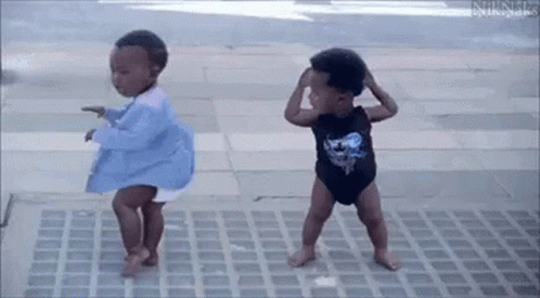 Two Baby Boys Are Dancing On A Sidewalk . GIF