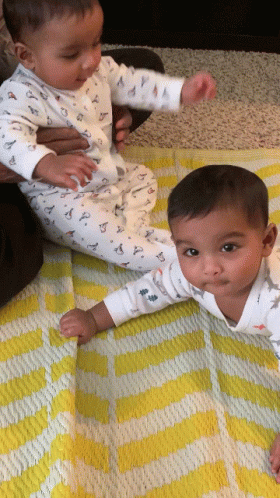 Two Baby Boys Laying on Yellow and White Blanket