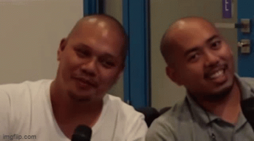 Two Bald Men Smiling Beside Microphone