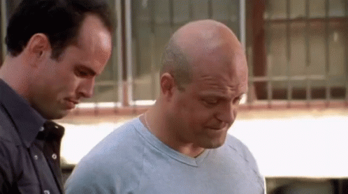 Two Bald Men Standing, One Looking Down