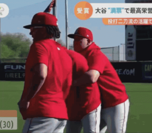 Two Baseball Players Are Hugging Each Other On A Field With A Lite Ad In The Background GIF