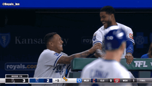 Two Baseball Players Are Shaking Hands In A Dugout With A Kansas City Ad Behind Them GIF