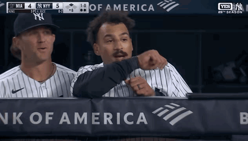 Two Baseball Players Behind A Bank Of America Banner During A Game GIF
