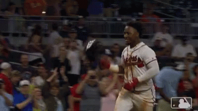 Two Baseball Players Celebrate In Front Of A Crowd With A Mlb Logo In The Corner GIF