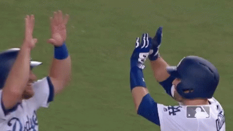 Two Baseball Players Hugging Each Other On The Field . GIF