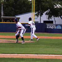 Two Baseball Players in Field With Regional 1902 Sign