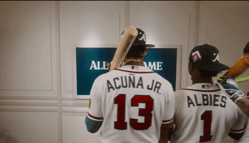 Two Baseball Players Standing In Front Of A Screen That Says All Star Game GIF