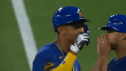 Two Baseball Players Wearing Blue And Yellow Uniforms With The Number 4 On The Sleeve GIF