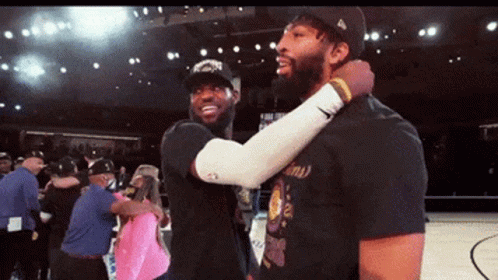 Two Basketball Players Are Hugging Each Other On A Basketball Court GIF