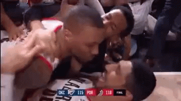 two basketball players are kissing each other in the stands .
