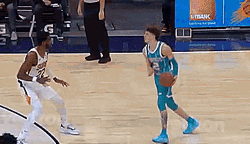 two basketball players are playing a game of basketball on a court and one of them is dribbling the ball .