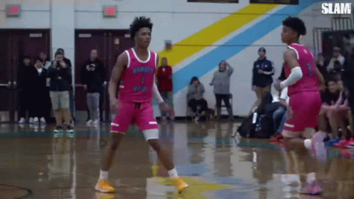 Two Basketball Players Are Playing A Game Of Basketball On A Court . GIF