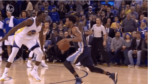 Two Basketball Players Are Playing A Game Of Basketball On A Court While A Referee Watches . GIF