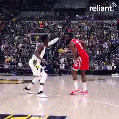 Two Basketball Players Are Playing A Game Of Basketball On A Court With A Crowd Watching . GIF