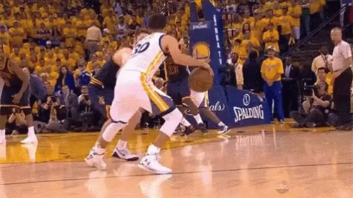 Two Basketball Players Are Playing A Game Of Basketball On A Court With A Spalding Sign In The Background . GIF