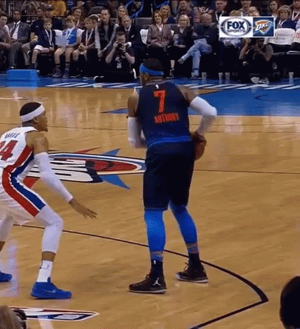 two basketball players are playing a game on a court . one of the players has the number 7 on his jersey .