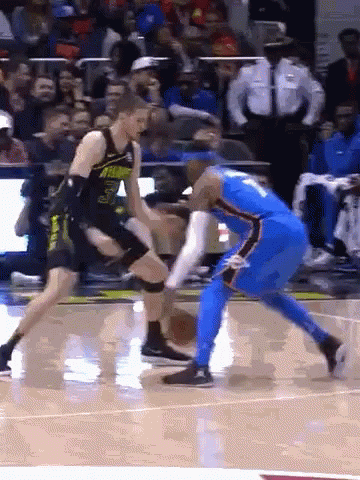 Two Basketball Players Are Playing A Game On A Court GIF