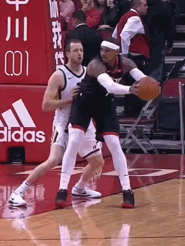 Two Basketball Players Are Playing A Game On A Court With An Adidas Sign In The Background GIF