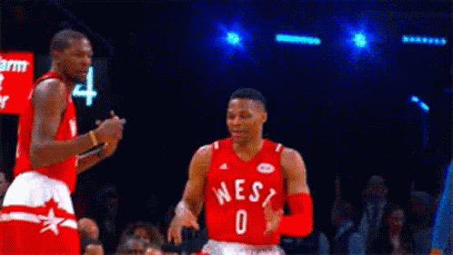 Two Basketball Players Are Standing Next To Each Other On A Court . GIF