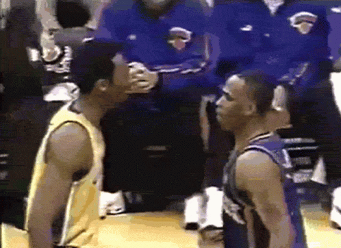 Two Basketball Players Are Standing Next To Each Other On The Court GIF