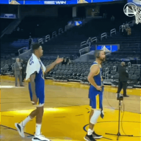 Two Basketball Players Are Standing On A Basketball Court Talking To Each Other GIF