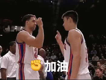 Two Basketball Players Giving Each Other A Fist Bump In Front Of A Crowd In A Stadium GIF