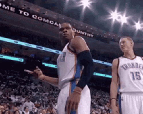 Two Basketball Players In Front Of Come To Comcast Country Sign GIF