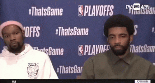 Two Basketball Players In Front Of Playoffs Wall GIF