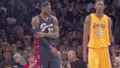 two basketball players standing next to each other one is wearing a lakers jersey and the other is wearing a cleveland j